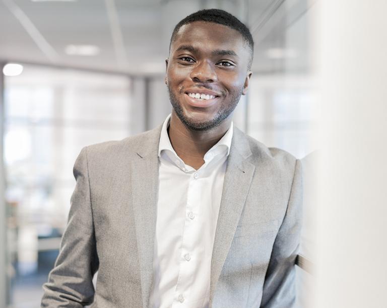Young male operations coordinator smiling at camera