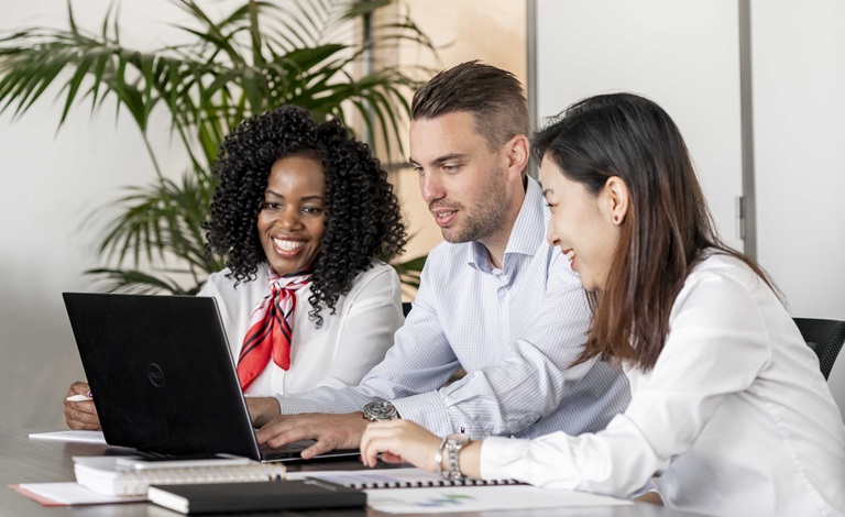 Three people working in international office environment