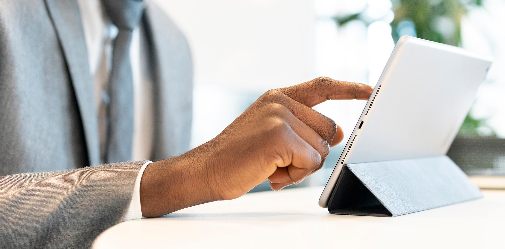 Man in suit using an electronic tablet device