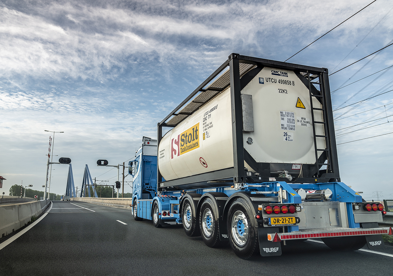Truck with a Stolt tank container driving on the road Truck with tank container driving on road