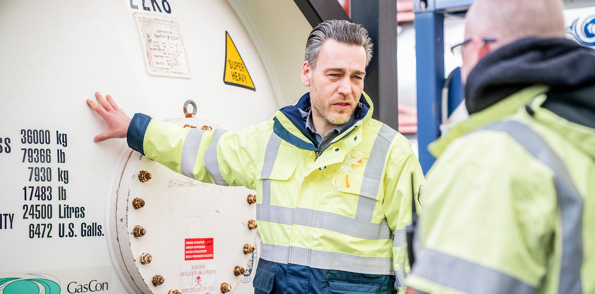Tank container specialist standing next to gas tank container