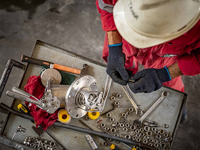 Depot worker doing maintenance of tank container element